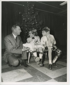 Mr. Burrows handing children Christmas gifts