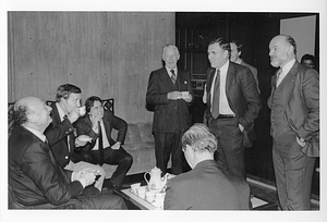 Mayor Raymond L. Flynn , New York Mayor Ed Koch, and a group of men seated around a table