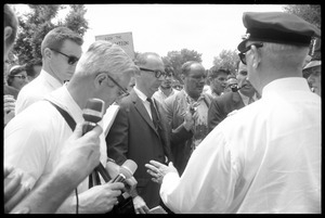 David Dellinger (center) being interviewed by the press after the Assembly of Unrepresented People peace march was attacked with red paint by right wing counterprotesters