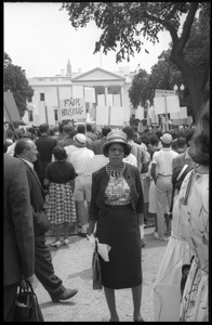 Middle-aged woman standing among civil rights protesters demanding fair housing at a demonstration in front of the White House
