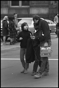 Man with a tape recorder interviewing two boys watching the Counter-inaugural demonstrations, 1969