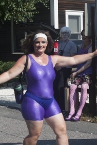 Woman in purple spandex sashaying down the street: Provincetown Carnival parade