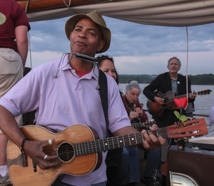 Guy Davis, Joanne Shenandoah (obscured), David Amram, and Tom Chapin (from left) making music aboard the Mystic Whaler during the Clearwater Folk Festival