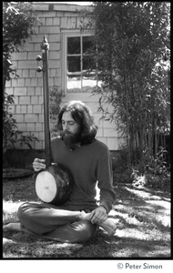 Krisha Das: portrait of the vocalist with Amazing Grace and member of the Ram Dass satsang, seated in a lotus position with an dotara