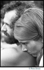Woman laying her head on the shoulder of a man as they listen to Ram Dass during his appearance at Andrews Amphitheater, University of Hawaii