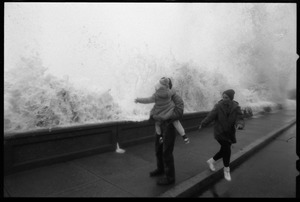 Judy Salonia, her husband Vincent, and daughter Ashley (4) watch as a huge surge crashes over the Narragansett seawall