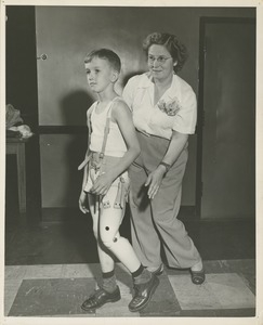 A young boy learns to walk with his prosthetic leg