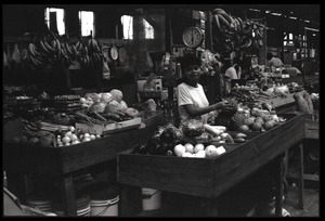 Woman operating a market stall in the old marketplace, selling fruit, Belize City
