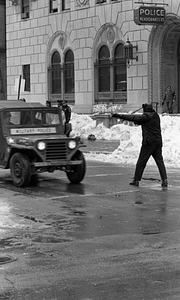 Unidentified officer directing Military Police vehicle in front of Boston Police Headquarters on Berkeley Street