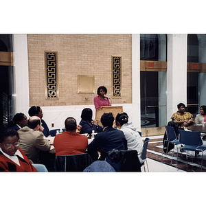 A woman stands at the lectern during a town hall meeting