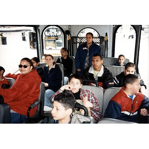 Villa Victoria children and chaperones seated on a bus or shuttle while on a field trip.