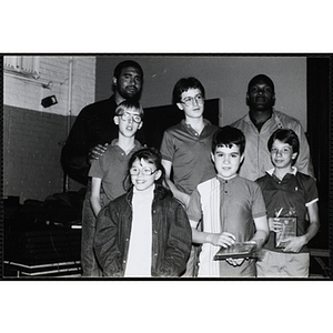 Two former Boston Celtics players, Sly Williams, left, and Sam Vincent, pose for a group picture with three boys and a girl holding their awards at a Kiwanis Club's awards ceremony