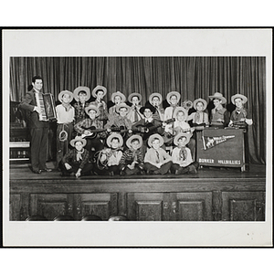 The Bunker Hillbillies pose for a group shot on a stage with an unidentified man holding an accordion