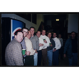 Eight Bunker Hillbilly alumni pose in a staggered line with their drinks at a reunion event