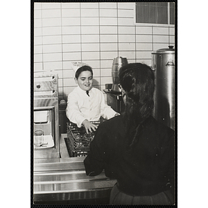 A member of Tom Pappas Chefs' Club assists a diner in a Brandeis University dining hall