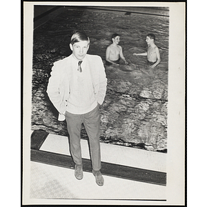 Francis Davis poses for a shot as two teenage boys wade in a natatorium pool in the background