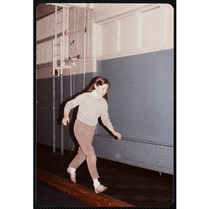 A girl walks on a balance beam at the Charlestown gymnasium