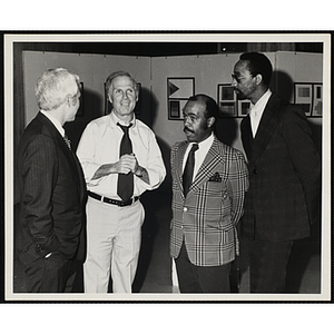 Boston mayor Kevin H. White stands in an art gallery with two unidentified men and Roxbury Clubhouse Director Roscoe Baker (far right)