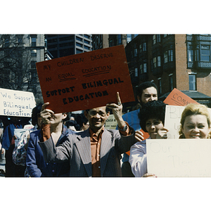 Demonstrators holding signs and protesting for bilingual education in schools at a rally on Beacon Street at the Massachusetts State House