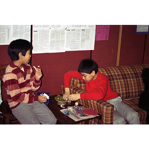 Two boys play with toys before a dinner at the Chinese Progressive Association Workers' Center
