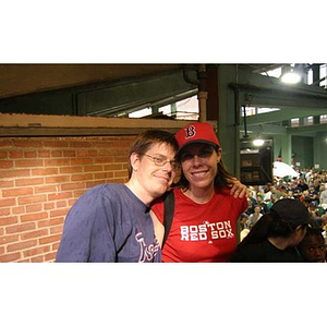 A man poses with Torch Scholars director Meghan Eliason at Fenway Park