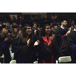 Female School of Law graduates clapping at commencement