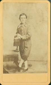 Full-length portrait of a boy, standing, facing front, location unknown, undated