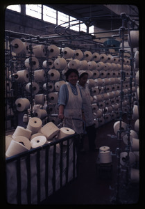 Cotton Mill No. 2: two women in front of spools, smiling