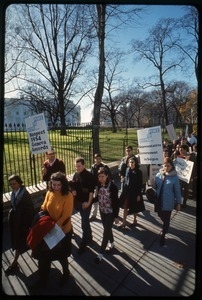 Antiwar protesters march past the white house with signs reading 'Steps to peace... respect 1954 Geneva Accords' and 'Steps to peace... representative government in Saigon': Washington Vietnam March for Peace