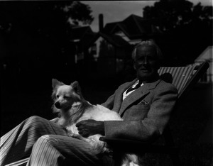 Charles Meyers and dog, reclining on a lawn