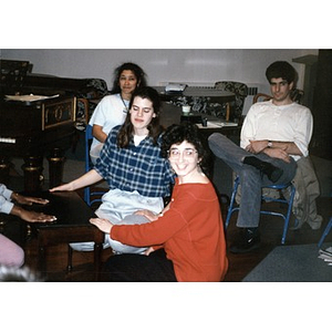 Three Inquilinos Boricuas en Acción employees kneeling at a coffee table at a staff retreat.