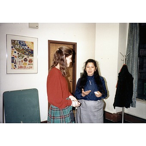 Clara Garcia speaking with a female staff member at what appears to be an office party.