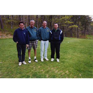 A four-man golf team posing on the golf course at the Charlestown Boys & Girls Club Annual Golf Tournament