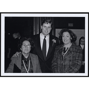 A man and two women posing for the camera at a St. Patrick's Day Luncheon