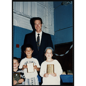 Former Boston Celtic Dave Cowens posing for a group picture with two boys and a girl at a Kiwanis Awards Night