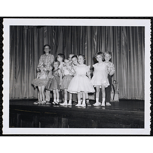 Five girls and their brothers standing together on the stage during a Boys' Club Little Sister Contest