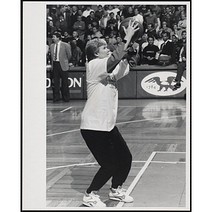 Sportswriter Jackie MacMullan holding a basketball and standing in shooting position at a fund-raising event held by the Boys and Girls Clubs of Boston and Boston Celtics