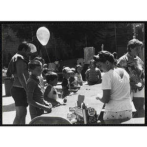 Children play a whiffle ball toss game at a carnival