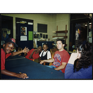 Site coordinator Josh Kraft sits with children at the Tri-Club youth leadership event at the Roxbury Clubhouse