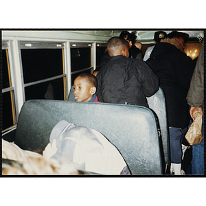 A group of children ride on a bus during a Tri-Club trip to Roller World