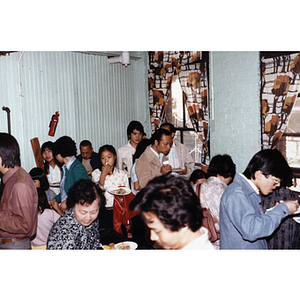 Community members talking and eating at a Chinese Progressive Association party
