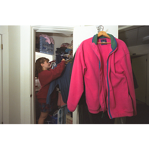 A student hangs a sweatshirt in her closet