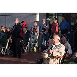 Several people watch the Veterans Memorial dedication ceremony