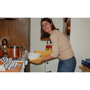 Meghan Allen-Eliason takes a dish out of the oven at the Torch Scholars Thanksgiving Dinner