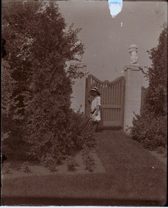 Child standing at the garden gate of the Saltonstall House, Milton, Mass.