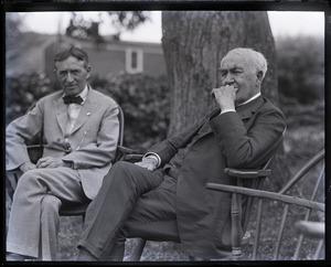 Group sitting on Windsor chairs on the lawn at the Fireside Inn: Harvey Firestone and Thomas A. Edison (l. to r.)