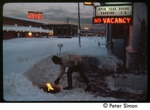 Lighting a fire outside a motel in deep snow