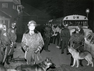 Police in riot gear and dogs, staging near UMass Amherst buses