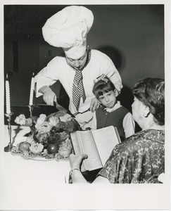 Chef carving turkey for young client