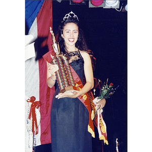 Yaritza Gonzalez wears a crown and sash while holding a large trophy